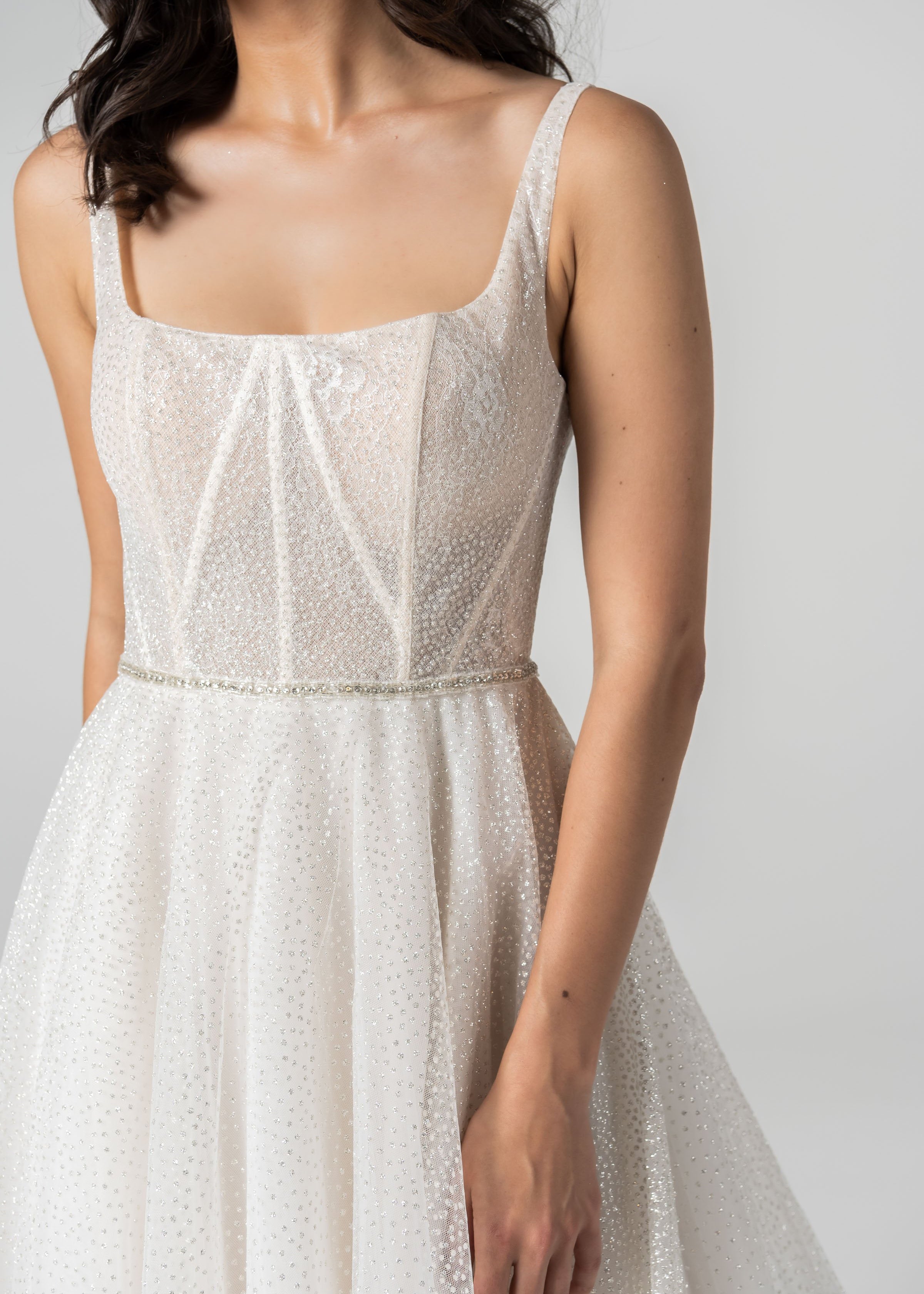 Detail close up shot of a Woman in a Sparkle Lace A-Line Wedding Dress in front of a white back drop