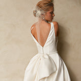 Close-up back view of textured Mikado A-line wedding dress with deep V-back, detachable bow, and bridal birdcage veil.