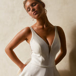 Close-up of textured Mikado A-line wedding dress bodice with deep V neckline and structured waist.
