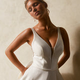 Close-up of textured Mikado A-line wedding dress bodice with deep V neckline and structured waist.
