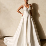 Textured Mikado A-line wedding dress with deep V neckline, structured bodice, and flowing chapel train.
