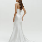 Woman wearing a strapless liquid organza fitted wedding dress on a white background