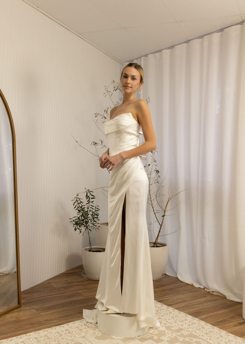 Woman in a strapless Two Piece Bridal Gown standing in a room with a neutral color scheme.