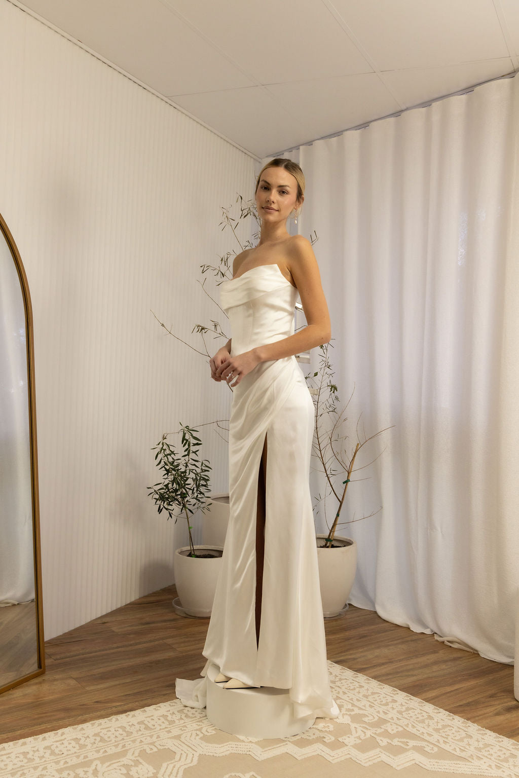 Woman in a strapless Two Piece Bridal Gown standing in a room with a neutral color scheme.