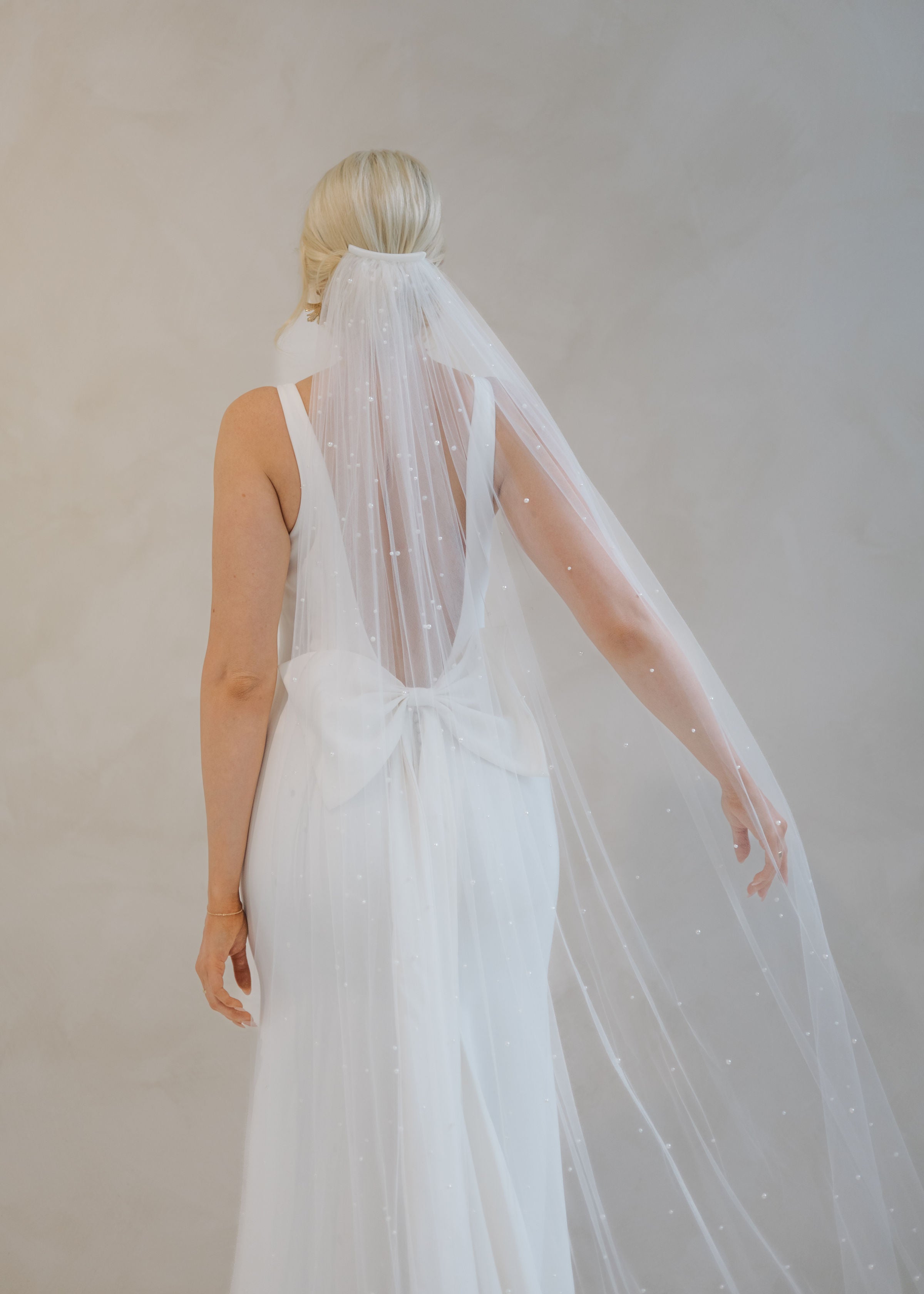 Back of a bride wearing a veil and a Crepe Fit and Flare Wedding Dress