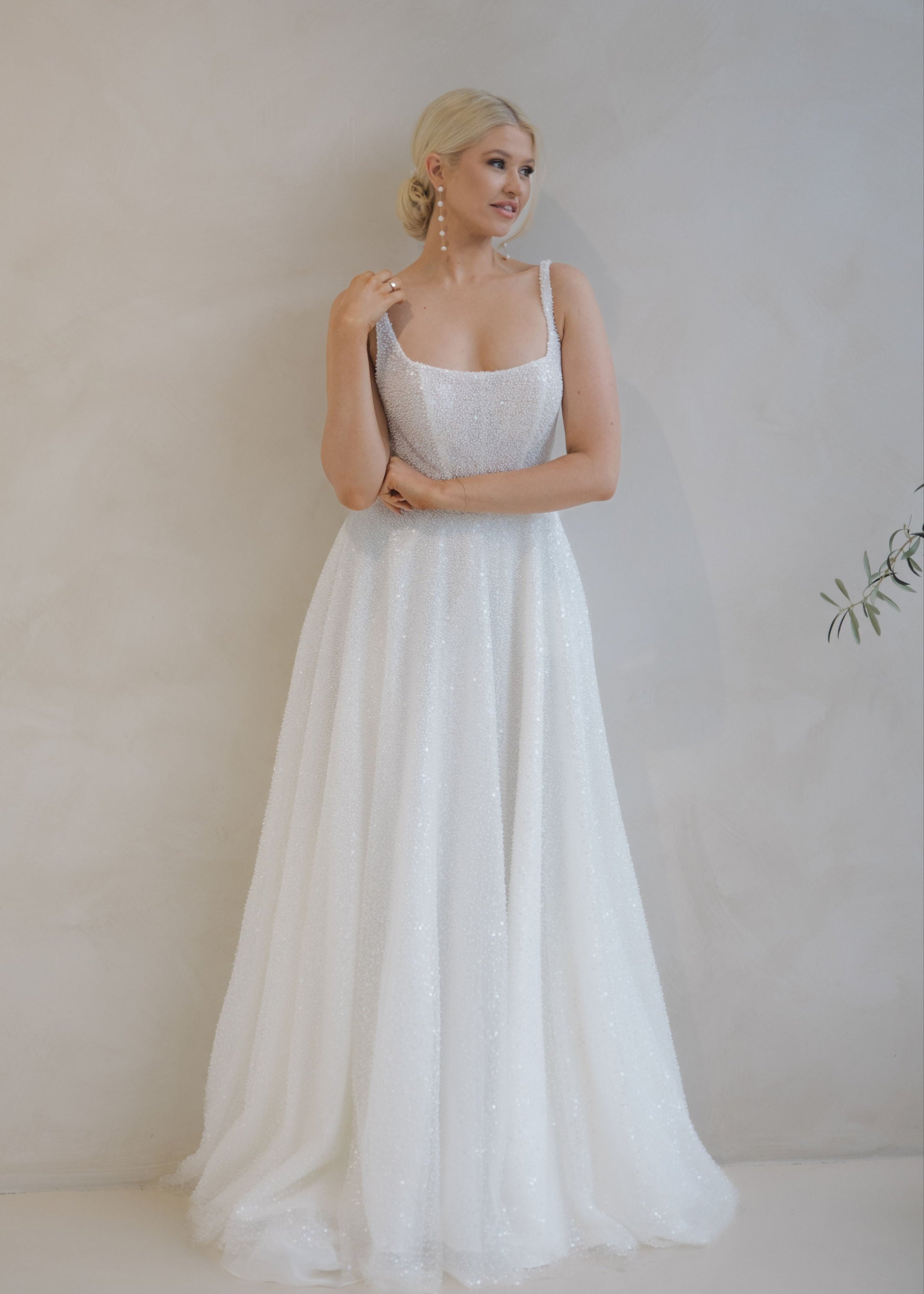 Woman wearing a Beaded A-Line Wedding Dress against a plain background