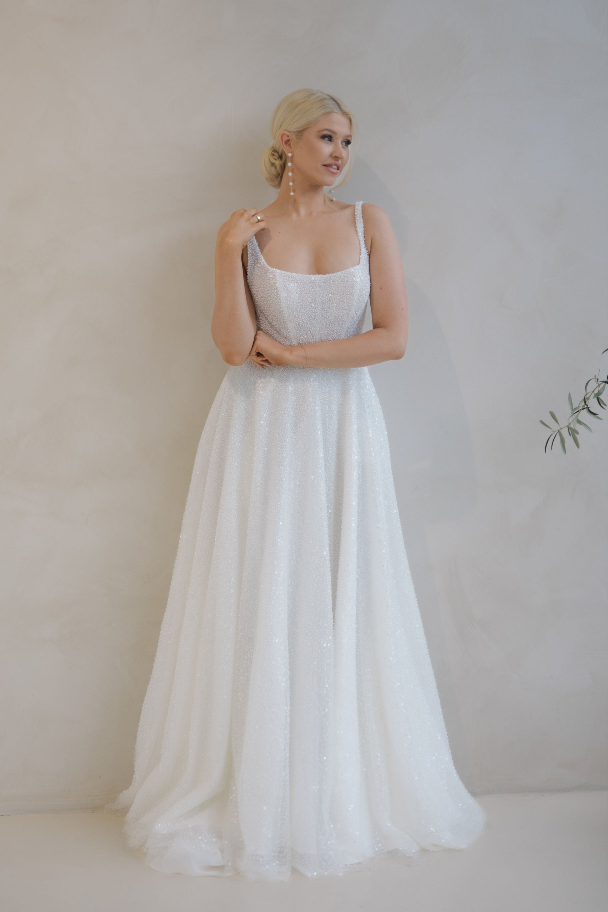 Woman wearing a Beaded A-Line Wedding Dress against a plain background