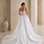 back view of a bride wearing a satin A-line wedding dress with square neckline in a garden