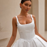 close up view of a bride wearing a satin A-line wedding dress with square neckline in a garden