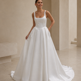 bride wearing a satin A-line wedding dress with square neckline in a garden