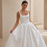 detail shot of a bride wearing a satin A-line wedding dress with square neckline in a garden