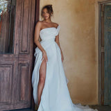 Woman in an organza A-line wedding dress standing in a rustic interior setting.