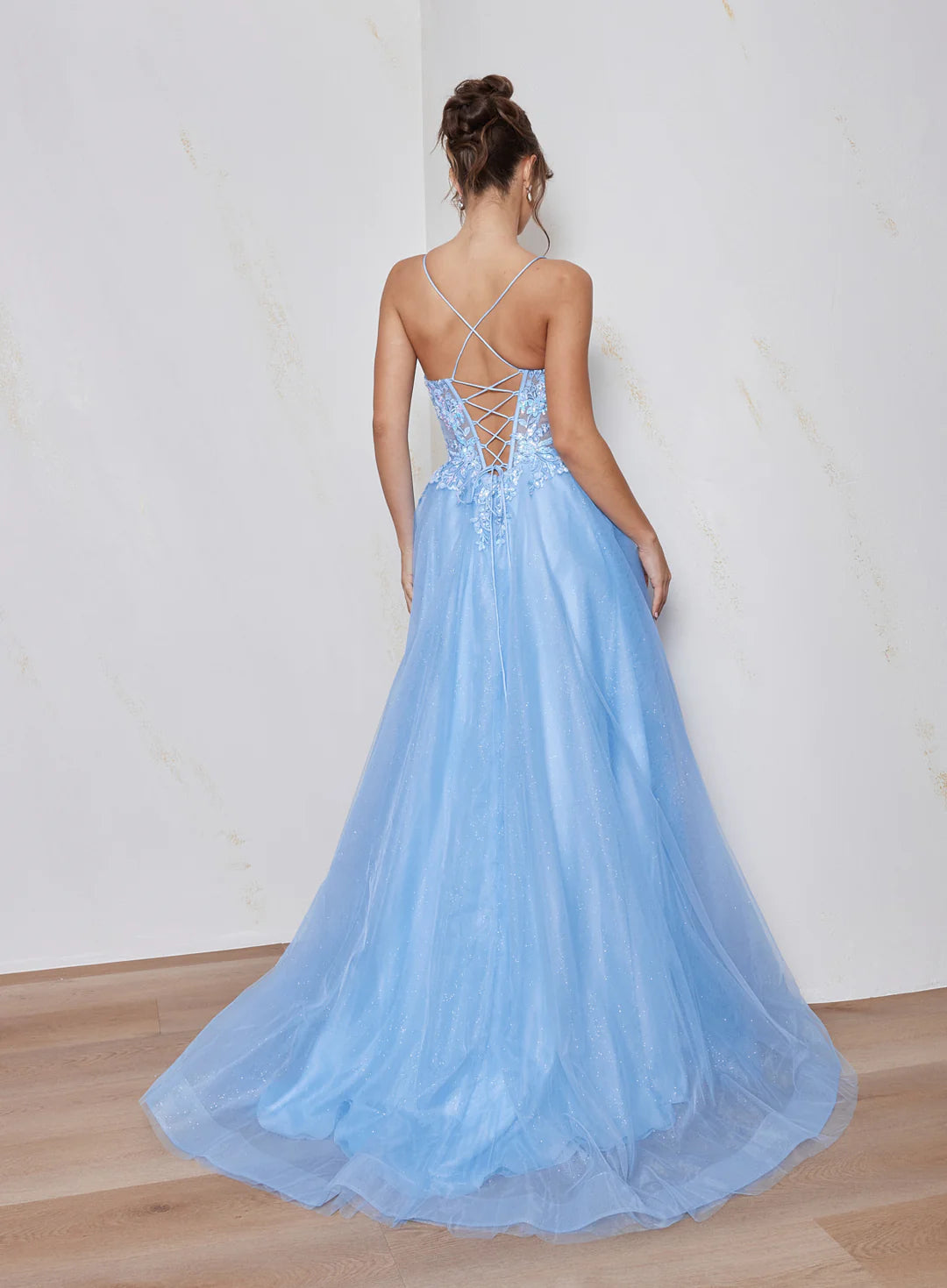 Woman wearing a light blue evening gown with a white background