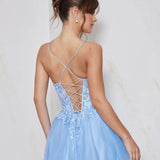 Woman wearing a light blue dress with a criss-cross back design on a plain background