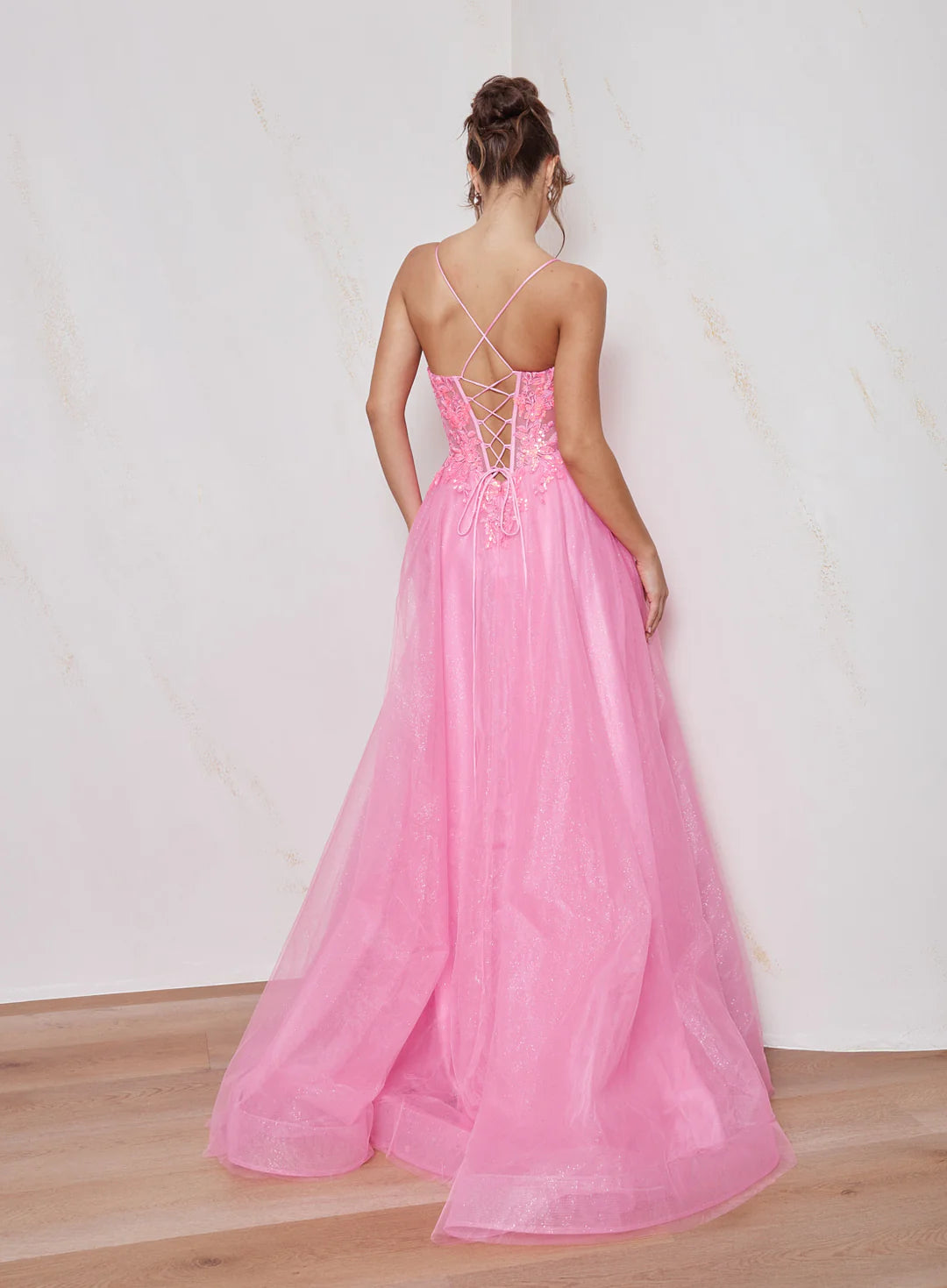 Pink evening gown with open back on a plain background