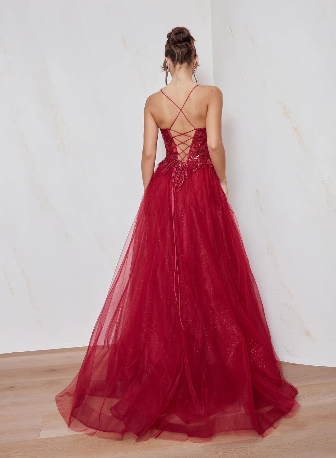 Red evening gown with intricate back design on a plain background