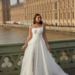 Woman in a organza A-line wedding dress standing on a bridge with the Houses of Parliament in the background.
