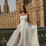 Woman in a organza A-line wedding dress standing on a bridge with the Houses of Parliament in the background.