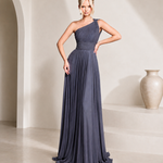 Woman wearing a one-shoulder blue gown in a minimalistic setting