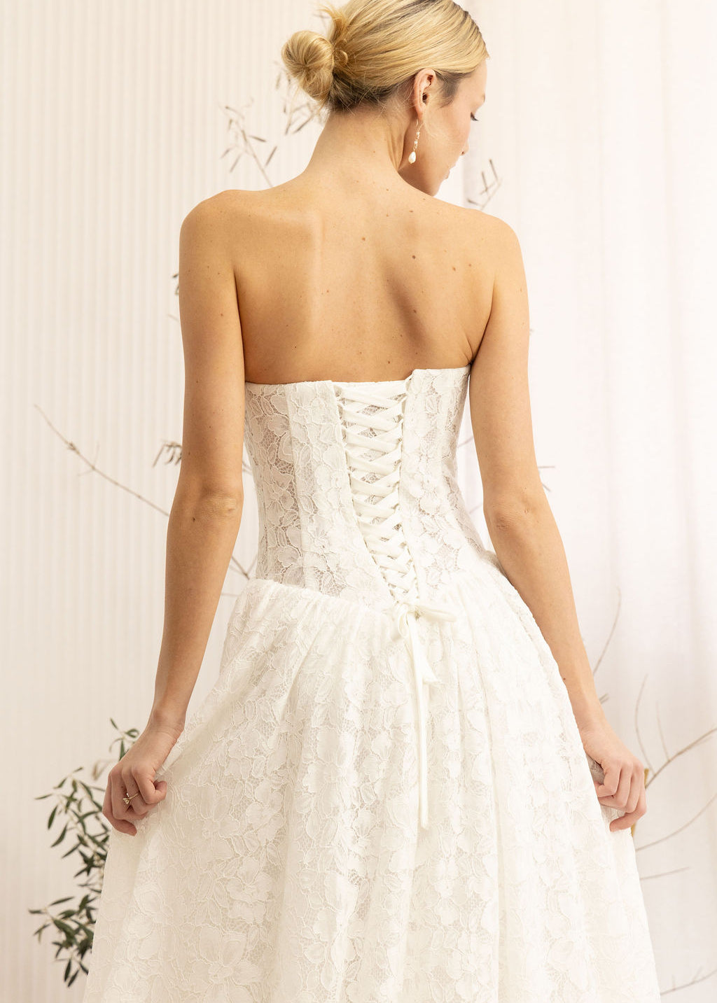 Woman wearing a Lace Strapless A-Line Wedding Dress against a neutral background