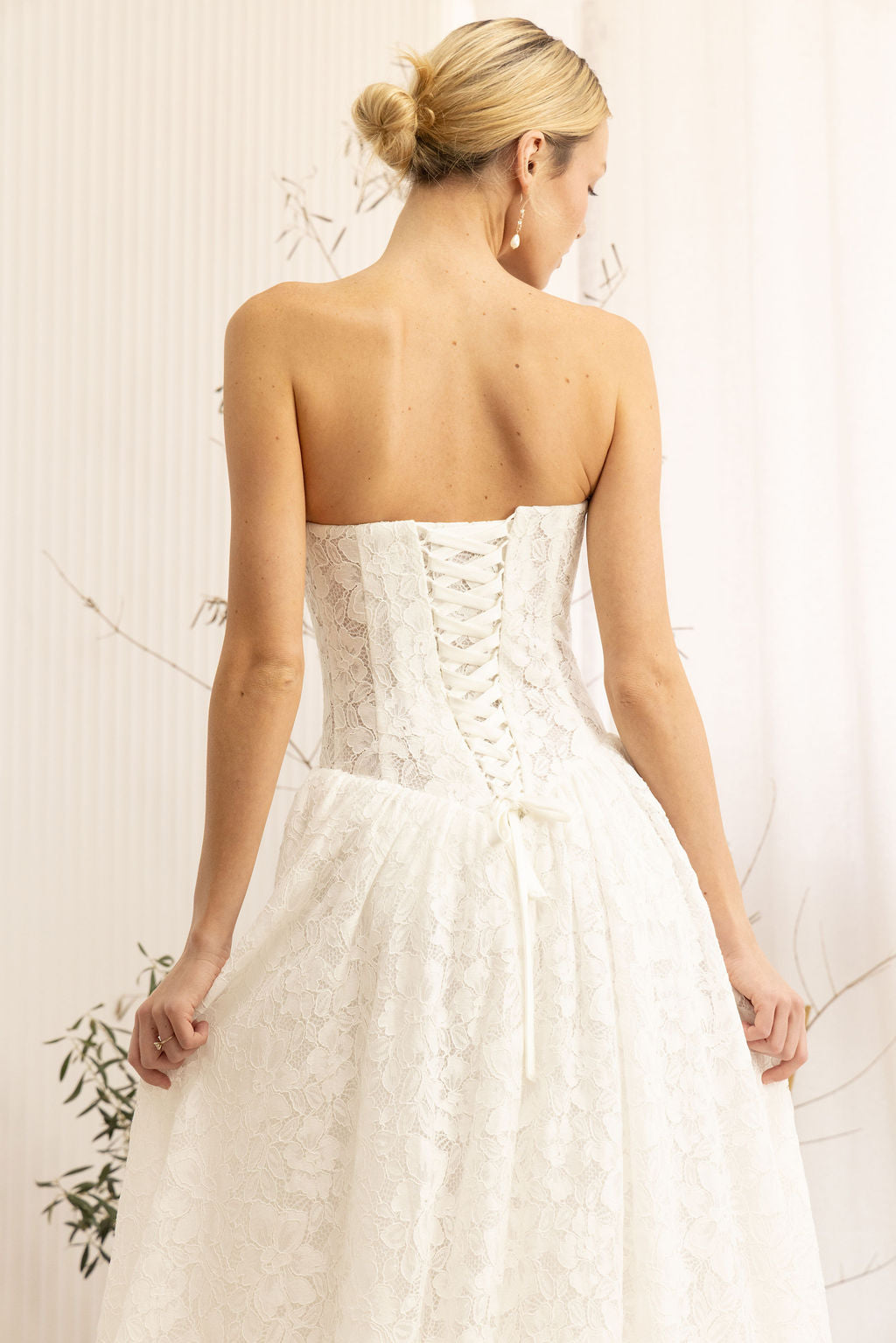 Woman wearing a Lace Strapless A-Line Wedding Dress against a neutral background