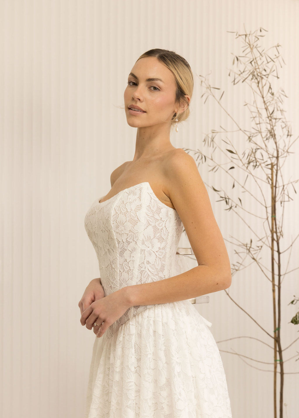 Woman wearing a Lace Strapless A-Line Wedding Dress against a neutral background