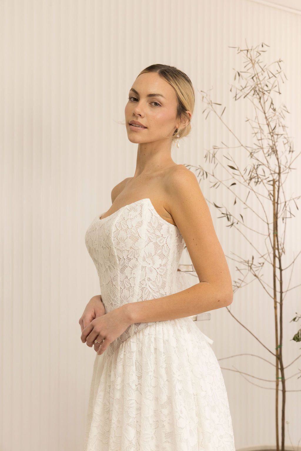 Woman wearing a Lace Strapless A-Line Wedding Dress against a neutral background