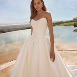 Woman in Ghada wedding dress by Modeca standing outdoors with a scenic background