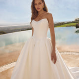 Woman in Ghada wedding dress by Modeca standing outdoors with a scenic background