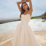 Woman in Ghada wedding dress by Modeca standing outdoors with a scenic background