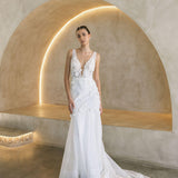 Woman in a Floral Fit and Flare Bridal Gown standing in a modern architectural setting with arches.
