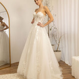 Woman trying on a Romantic Lace Wedding Dress in a room with a mirror and decor.