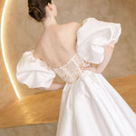 Heston wedding dress back view with lace bodice detail, puff sleeves and full satin skirt with train.