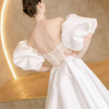 Heston wedding dress back view with lace bodice detail, puff sleeves and full satin skirt with train.
