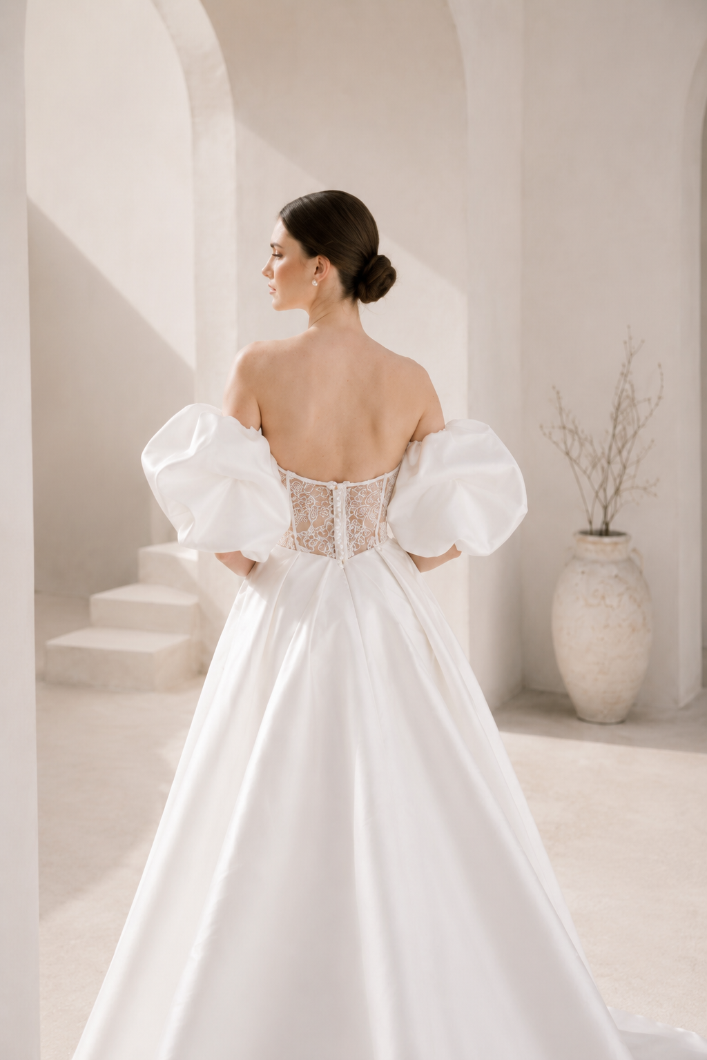 Heston wedding dress back view with lace bodice detail, puff sleeves and full satin skirt with train.