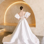 Heston wedding dress back view with lace bodice detail, puff sleeves and full satin skirt with train.
