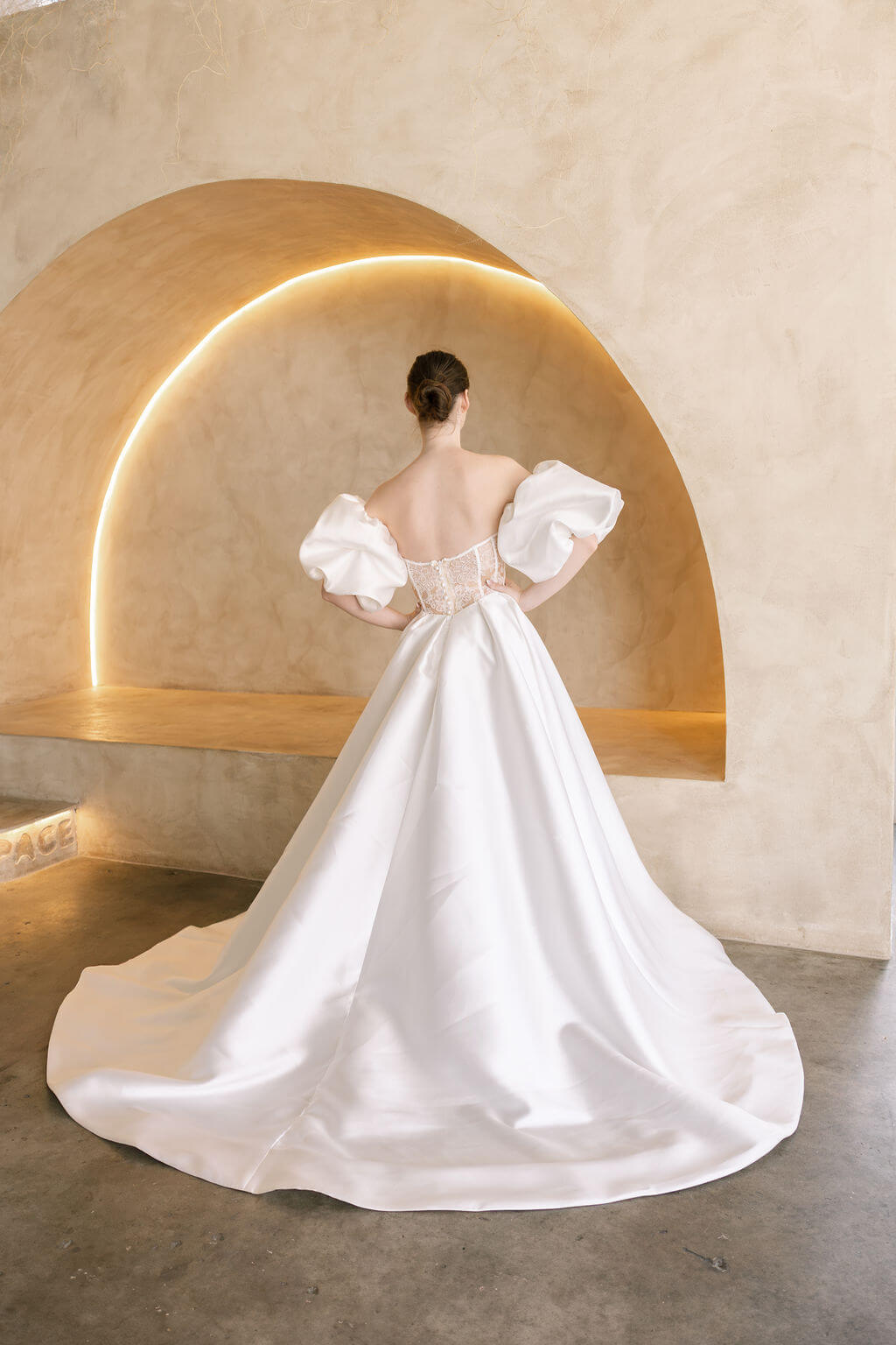 Heston wedding dress back view with lace bodice detail, puff sleeves and full satin skirt with train.