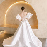 Heston wedding dress back view with lace bodice detail, puff sleeves and full satin skirt with train.
