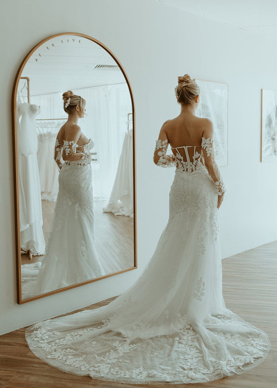 Woman in a Lace Fit and Flare Wedding Dress standing in front of a mirror.