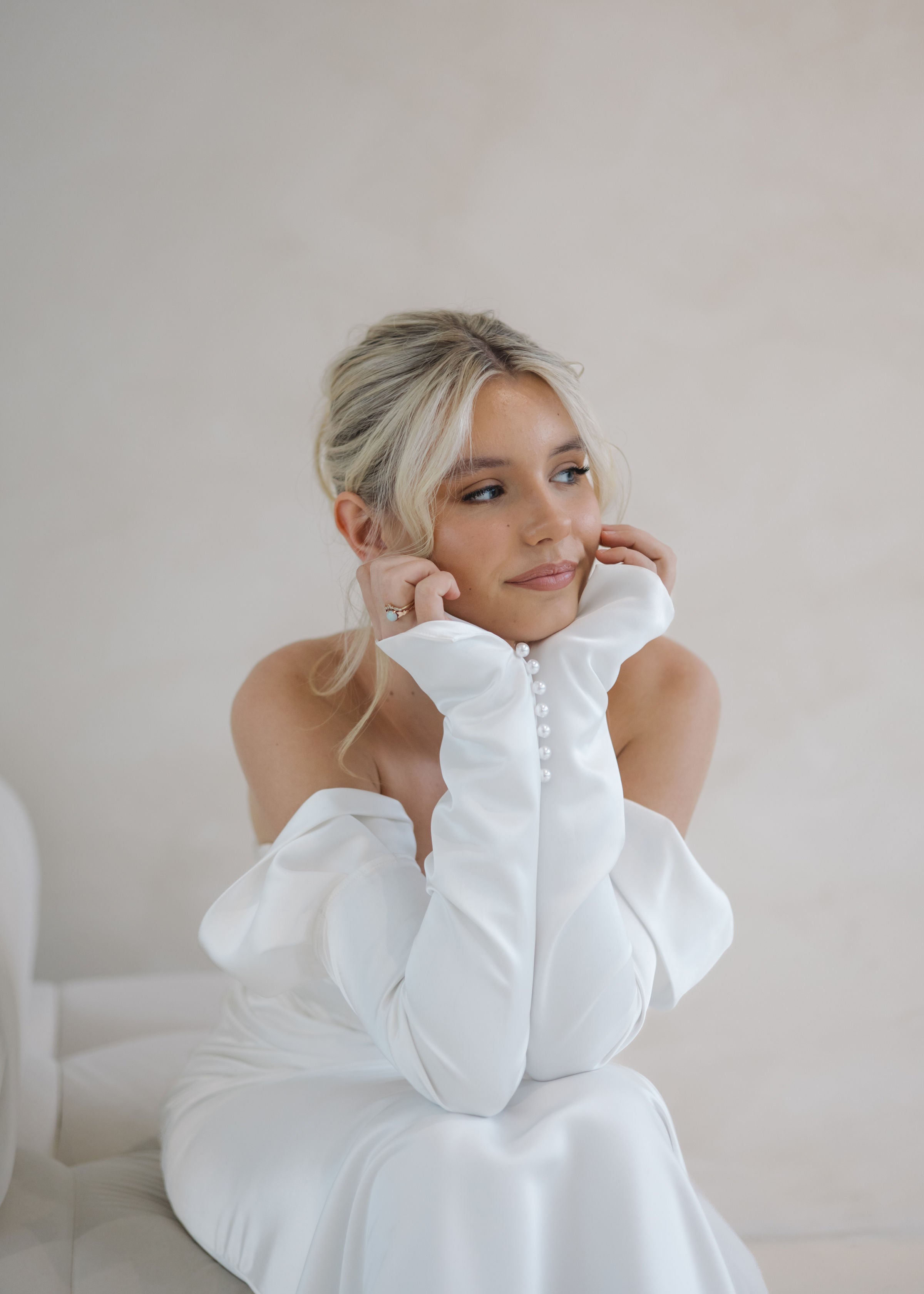 Bride wearing the Intentions crepe satin fit-and-flare wedding dress with sweetheart neckline and off-shoulder sleeves.