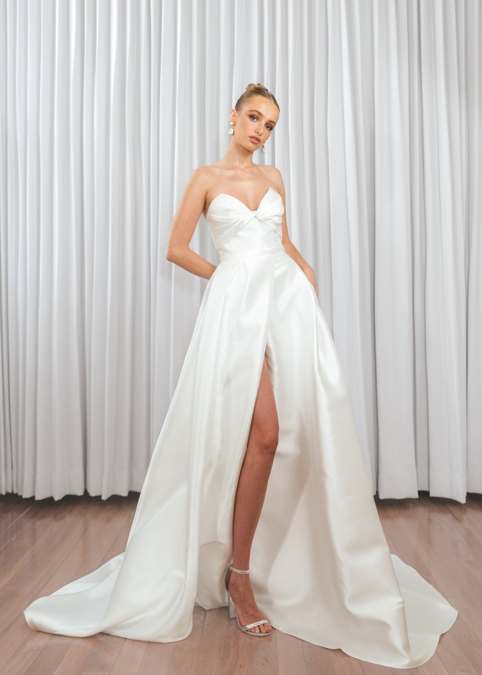 Bride wearing Marigold Mikado A-line wedding dress with strapless sweetheart bodice and dramatic front split.

