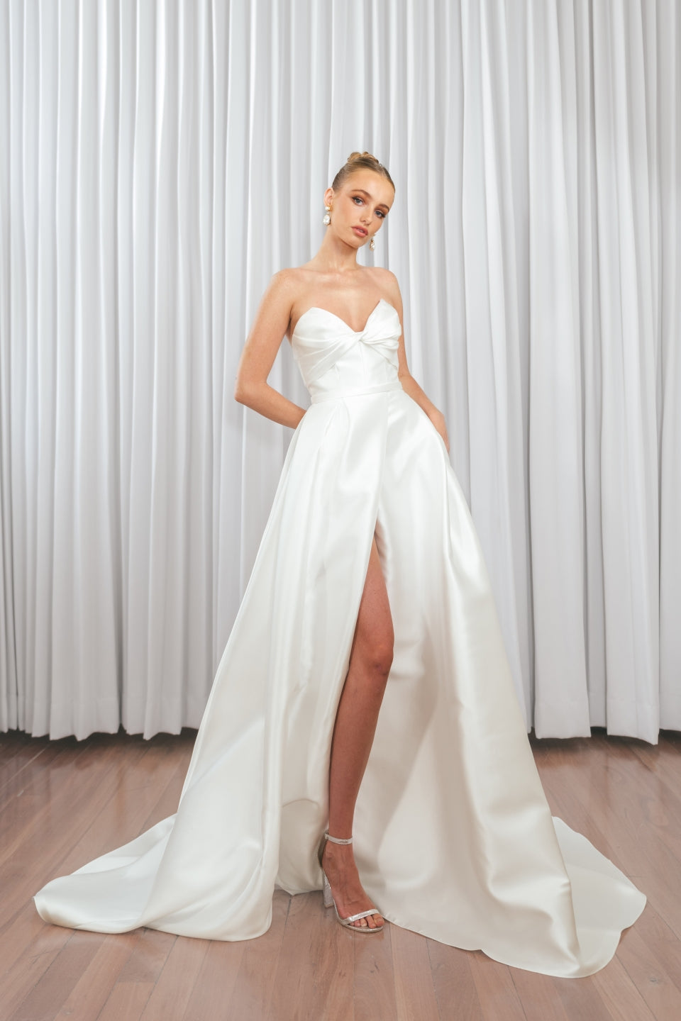 Bride wearing Marigold Mikado A-line wedding dress with strapless sweetheart bodice and dramatic front split.
