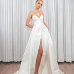 Bride wearing Marigold Mikado A-line wedding dress with strapless sweetheart bodice and dramatic front split.

