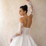 Woman wearing a white lace wedding dress against a neutral background