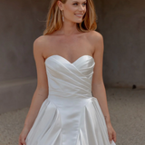 Woman wearing an AFTER FIVE heavy satin A-line wedding dress against a neutral background