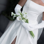 A close up of Queen wedding dress in Brisbane featuring off-shoulder neckline, long gloves and elegant front split
