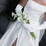 A close up of Queen wedding dress in Brisbane featuring off-shoulder neckline, long gloves and elegant front split