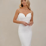 Bride wearing an after five crepe mermaid wedding dress infant of a neutral background