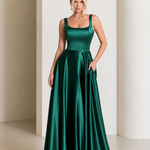 Woman wearing a green satin dress against a neutral background