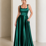 Woman wearing a green satin dress against a neutral background